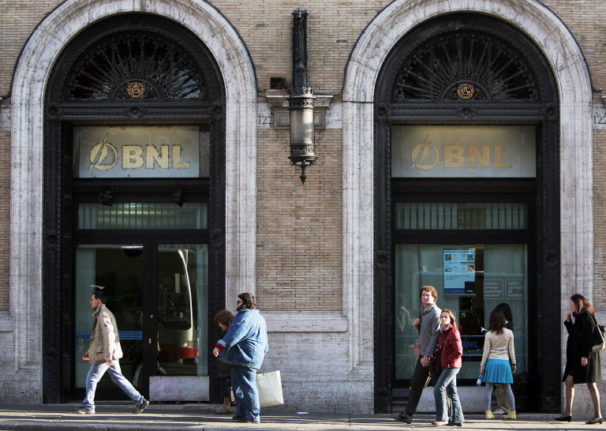 Pedestrians pass by a branch of Italy's Banca Nazionale del Lavoro in Rome