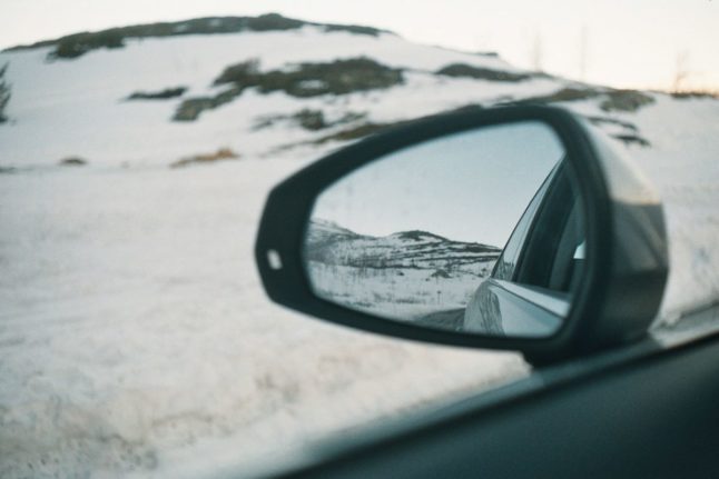 Pictured is a car wing mirror on a Norwegian road.