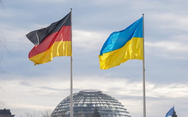 The German and Ukrainian flag fly next to the Bundestag in Berlin.