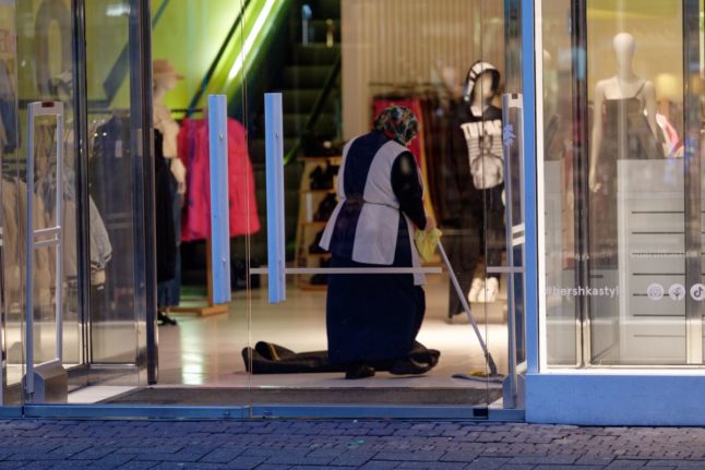 woman cleans a store front