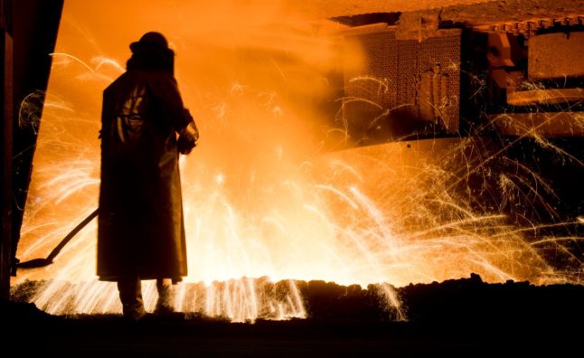 worker in front of a blast furnace