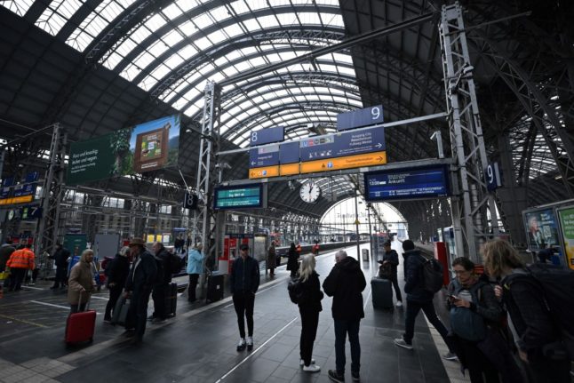 Rail passengers walk or wait at the main train station in Frankfurt am Main,