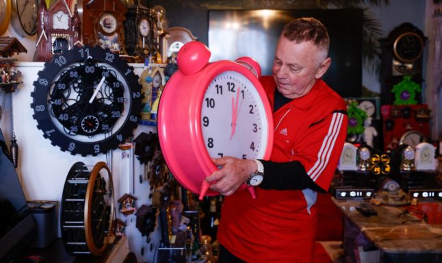 Werner Stechbarth (76) sets one of the clocks from his 366-strong collection in his living room in Munich, southern Germany