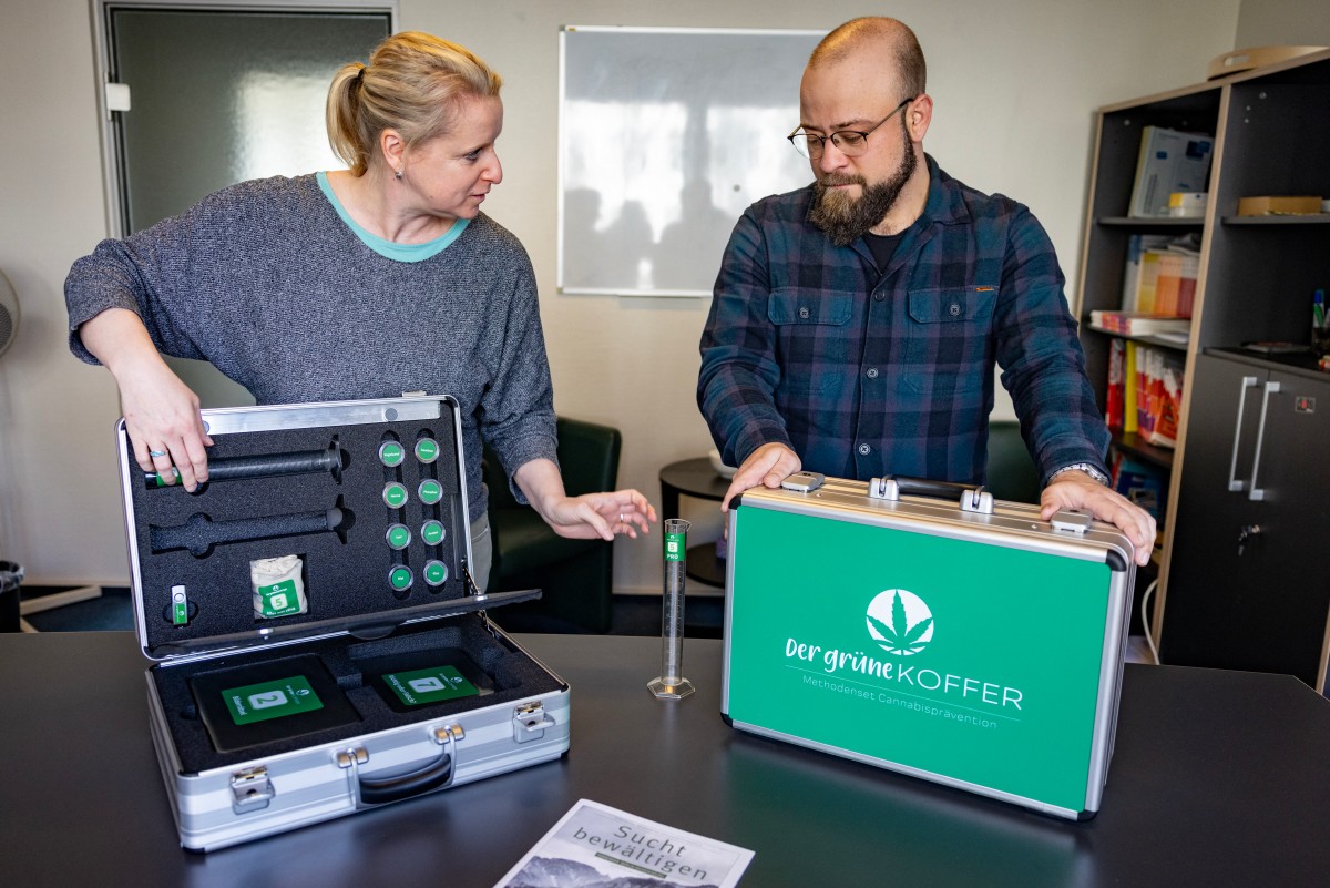 "Tannenhof Berlin-Brandenburg" addiction therapist Katja Seidel (L) and colleague Pascal Noack (R) demonstrate  "The Green Case" during an interview with AFP in Berlin, on March 27, 2024, a suitcase containing a kit used to communicate with students during a cannabis prevention visit to schools in Berlin and Brandenburg.