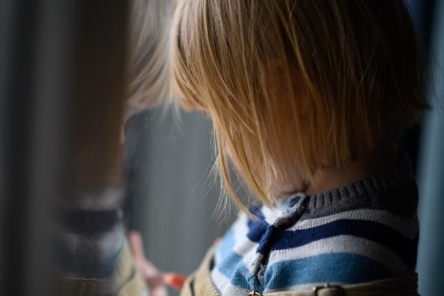 A child looks out the window. How can you get mental health help for children in Germany?