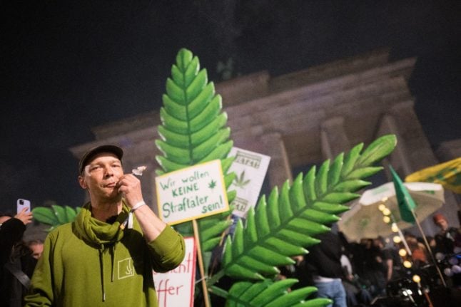 A participant at a rally at Brandenburg Gate in Berlin smokes a joint.