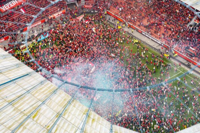 Thousands of Bayer Leverkusen fans storm the pitch after the 5-0 victory on Sunday.
