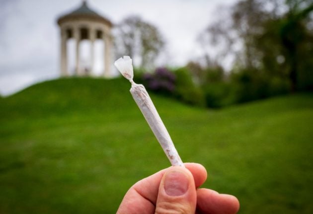 A person holds a joint at Munich's Englischer Garten.