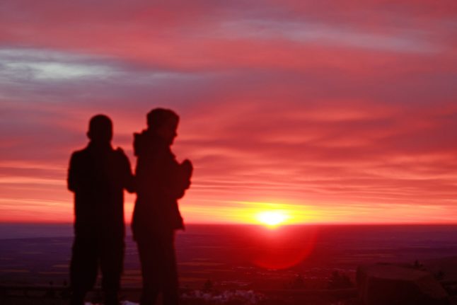 Hikers stand on the summit of the Brocken mountain in Germany on Sunday to enjoy the sunrise.