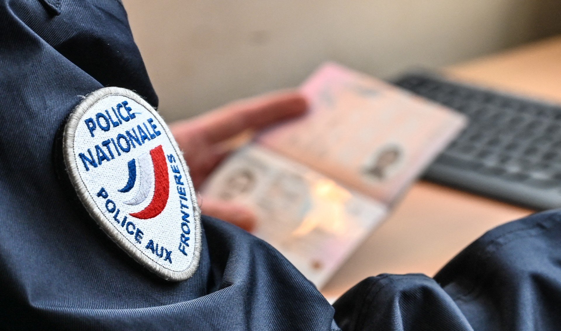 A French border guard checks a passport at the border