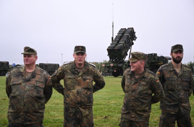 Soldiers of the German Armed Forces Bundeswehr stand in front of a Patriot missile system during the German Chancellor's visit to the military part of the airport in Cologne-Wahn