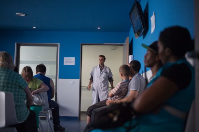 A doctor calls a patient in the waiting room at the surgery consultation at Argenteuil hospital, north of Paris