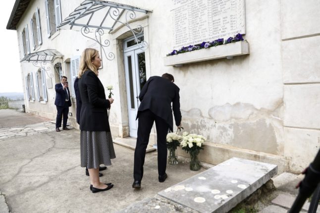 French President Emmanuel Macron lays flowers in front of a commemorative plaque near National Assembly's president Yael Braun-Pivet at the Maison d'Izieu memorial, as part of his visit to mark 80 years since Nazi forces raided the then Jewish orphanage