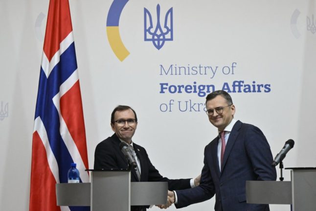 Pictured is Ukraine's Foreign Minister Dmytro Kuleba (R) shakes hands with Norway's Foreign Minister Espen Barth Eide (L)