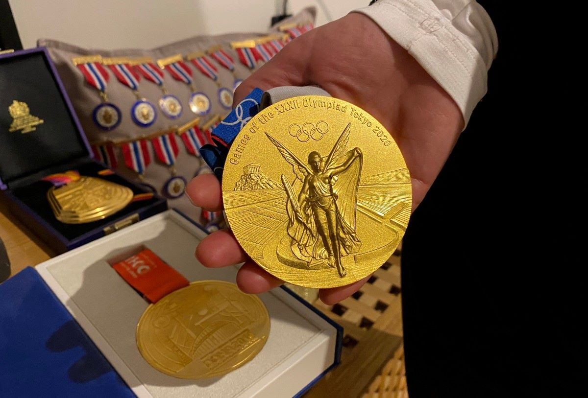 A close up of Karston Warholm's mother holding an Olympic gold medal. 