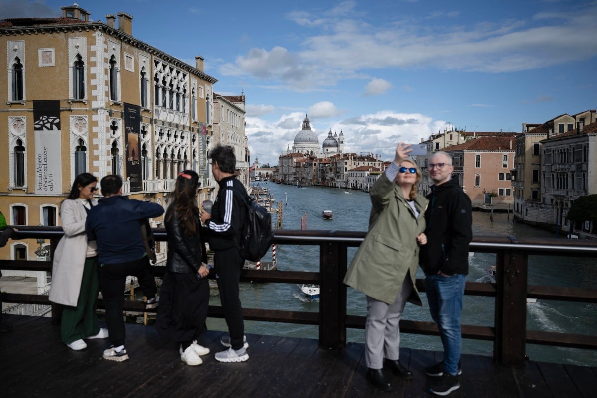 ourists take selfies with the Grand Canal