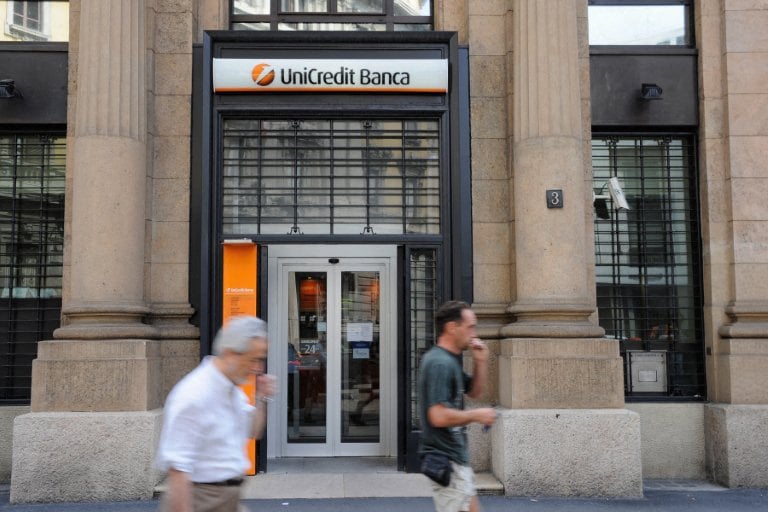 People walk past a branch of Italy's UniCredit bank in Milan