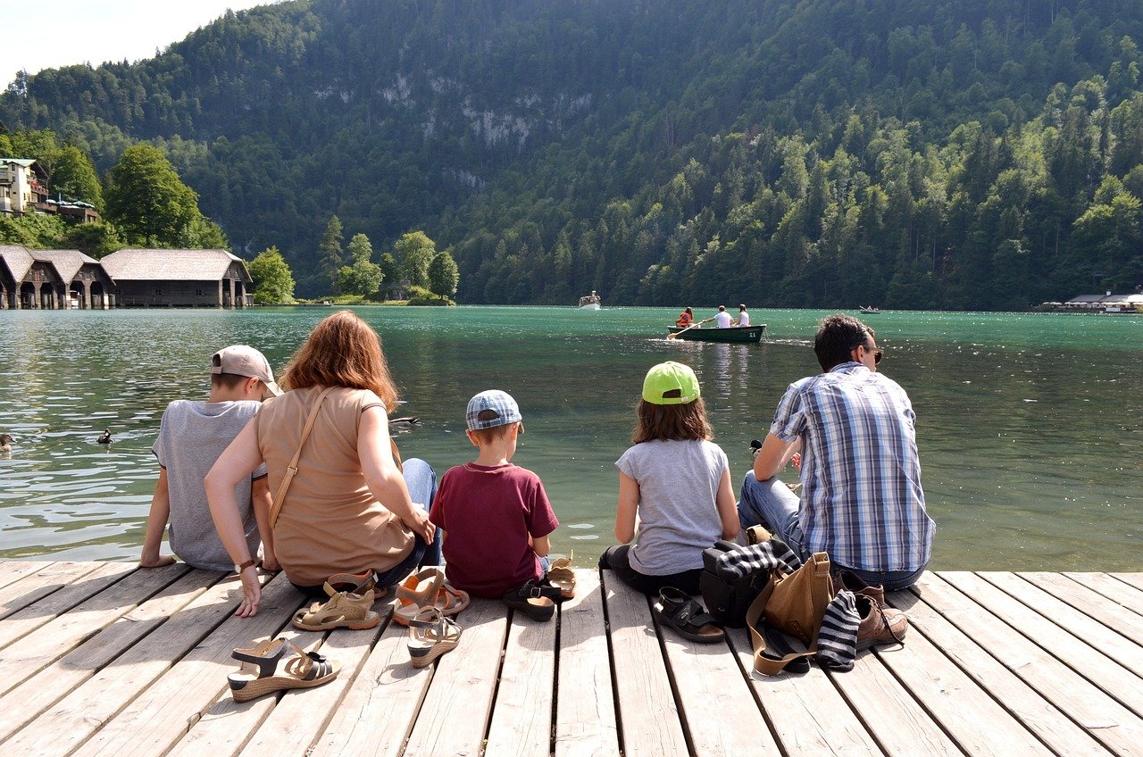 A family sit at a lake.