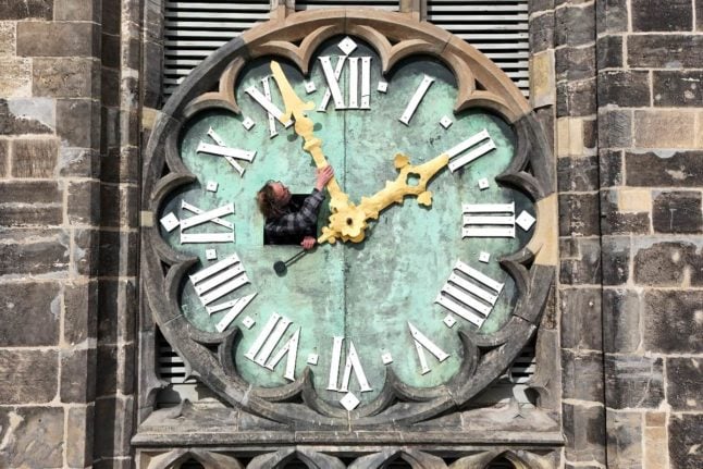 Uwe Jahn, of Magdeburg Cathedral, checks the hands of the southern tower clock through a hatch.