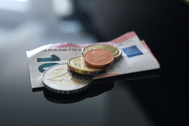 Euro notes and coins lie on a table