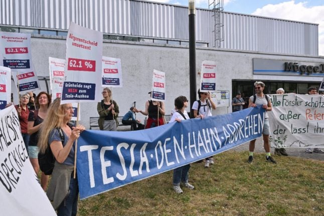 Participants in the alliance initiative ‘Tesla den Hahn abdrehen’ (‘Tesla turn off the tap’) protest in front of the Müggelspreehalle in Hangelsberg, Grünheide, where local councillors were voting on the expansion plans.
