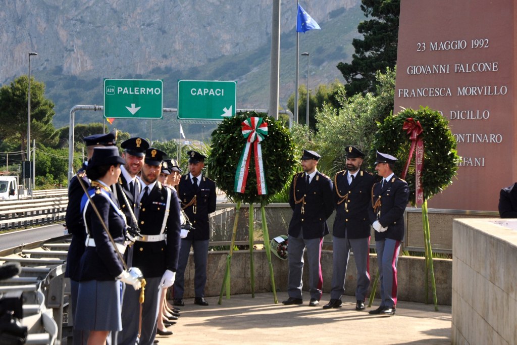 Italian police officers stand in front of a memorial honouring anti-mafia judge Giovanni Falcone