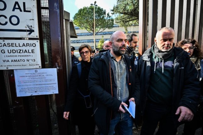Italian reporter Roberto Saviano (C) leaves court