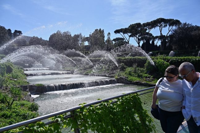 A couple walk past a water feature at the EUR Lake Park on the outskirts of Rome on April 13, 2024.