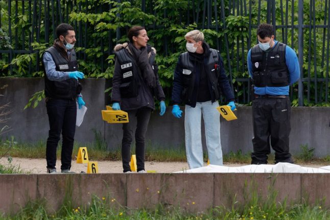 Police officers examining the scene where two men were shot dead, in Sevran, northern Paris