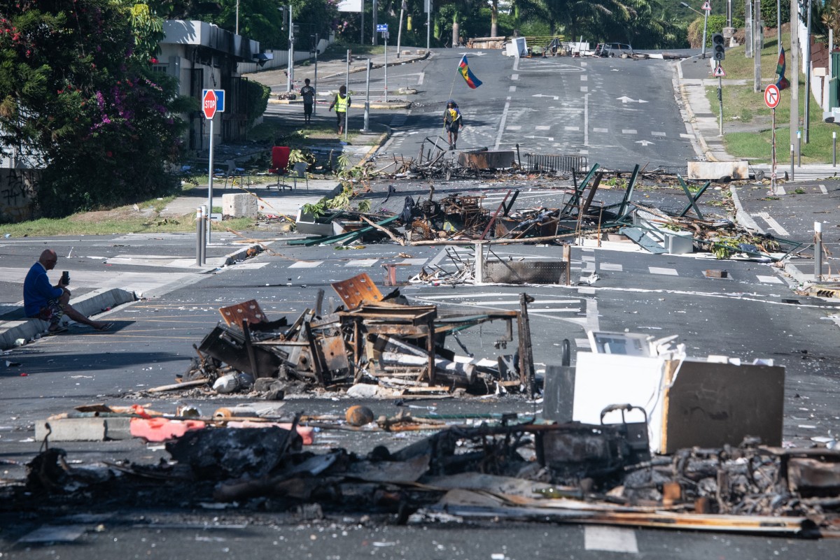 A street blocked by debris and burnt out items is seen following overnight unrest in the Magenta district of Noumea,
