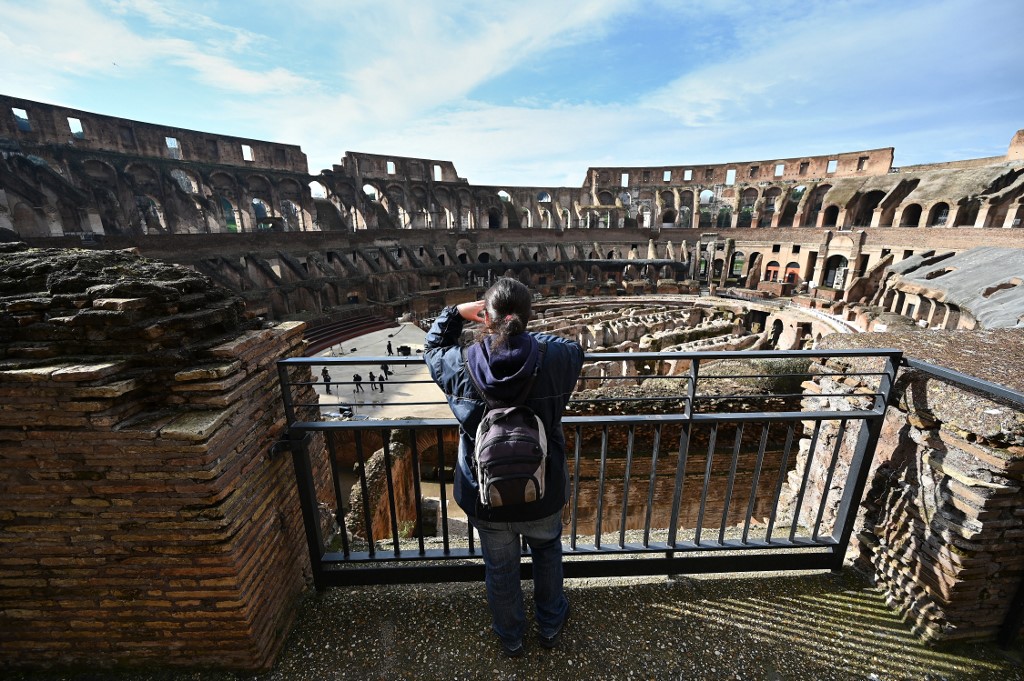 A tourist takes a picture of Rome's Colosseum