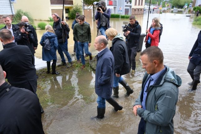 German Chancellor Olaf Scholz (L) and Saarland State premier Anke Rehlinger (R) wades through water as they visit flood stricken town of Kleinblittersdorf.