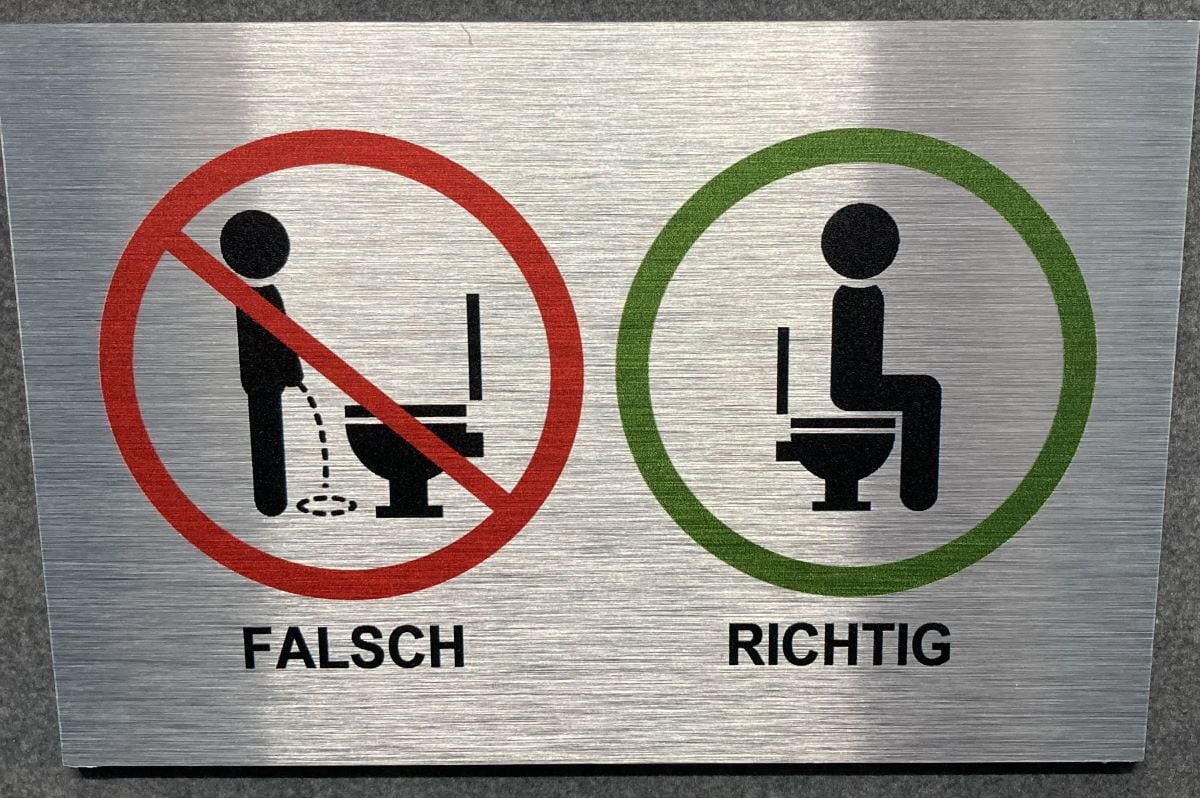 sit down while peeing sign in Germany