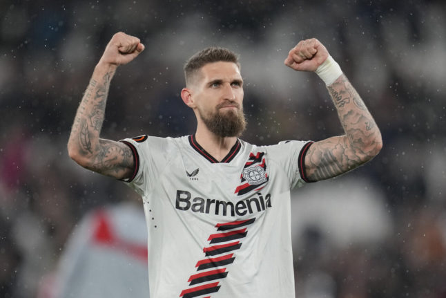 Leverkusen's Robert Andrich cheers after a game against West Ham United. Leverkusen is offering fans free tattoos after winning the German football championship.