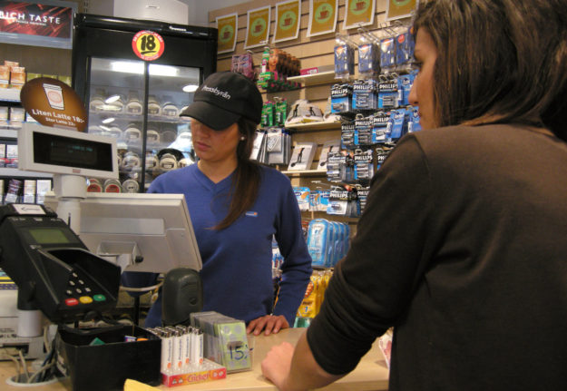a woman being served at the till at pressbyrån