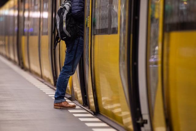 A man steps off the platform into a subway train in Berlin.
