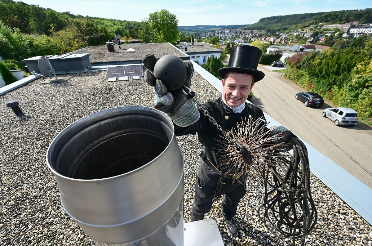 A chimney sweep on a roof on Maulbronn, Baden-Württemberg in 2023.