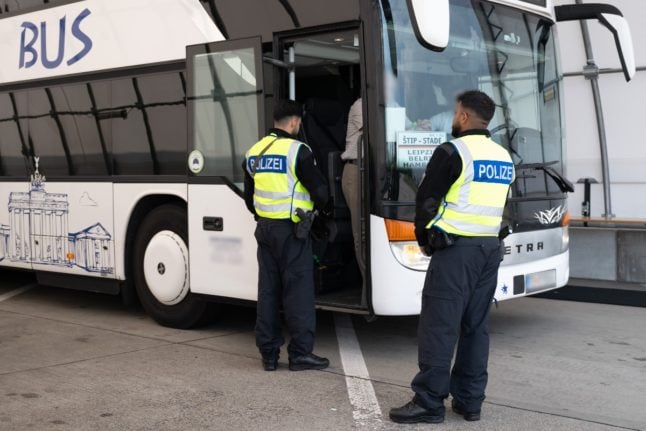 Police officers stand in front of a coach from North Macedonia at the “Am Heideholz” rest area on Autobahn 17 near the German-Czech border during border controls before the start of Euro 2024.