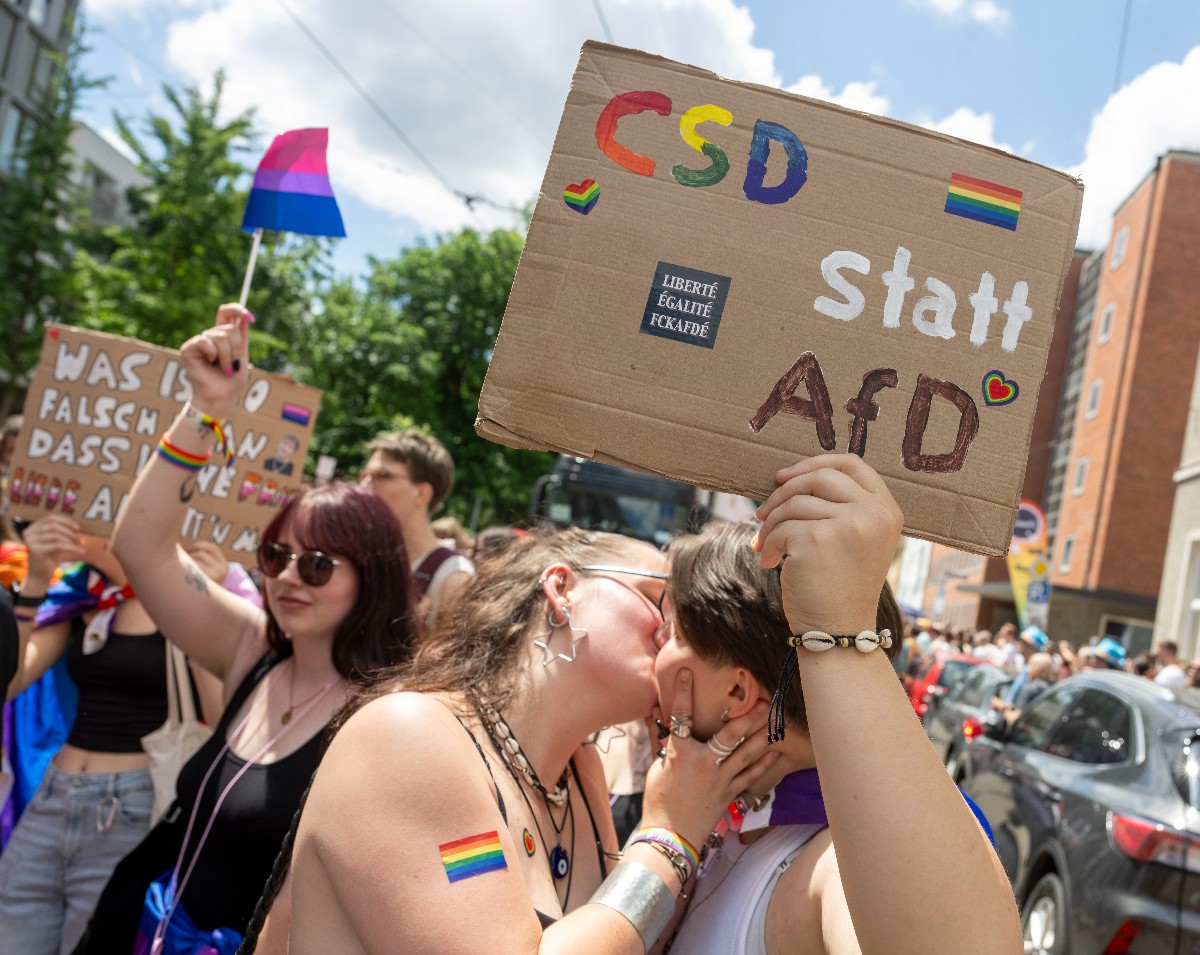 Two people kiss under a banner that says 'CSD instead of AfD' at the pride event in Munich on Saturday. 