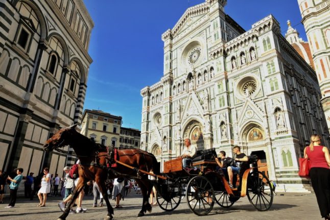 Tourists pictured on a horse carriage in front of Florence's central Santa Maria del Fiore Cathedral
