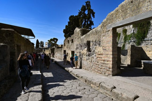 Visitors walk through the archaeological site of Herculaneum