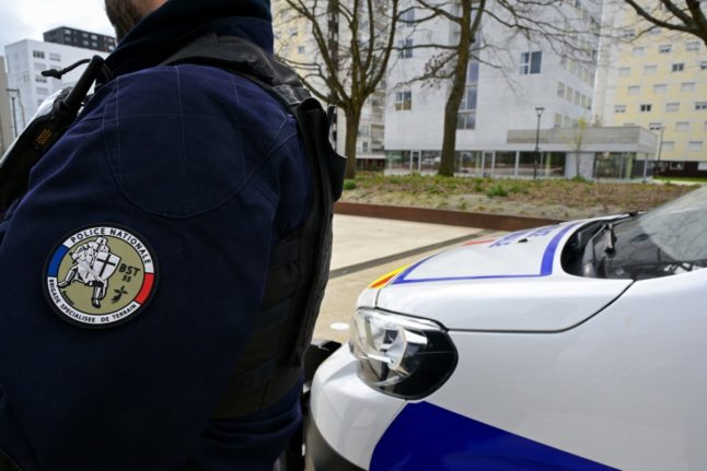 A French police officer standing next to a police van