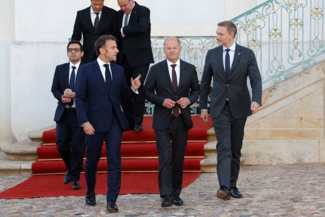 French President Emmanuel Macron (2ndL) and German Chancellor Olaf Scholz (2ndR) arrive with fellow ministers German Finance Minister Christian Lindner (R) and French Foreign Minister Stephane Sejourne (L) and others for a family photo at the end of a joint Franco-German cabinet meeting of ministers near Berlin on May 28, 2024.