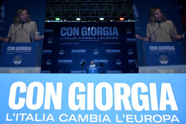Italian Prime Minister Giorgia Meloni delivers a speech during a campaign meeting for her far-right party Brothers of Italy for the upcoming European elections, on June 1, 2024 in Rome. The banner reads 'With Giorgia, Italy changes Europe