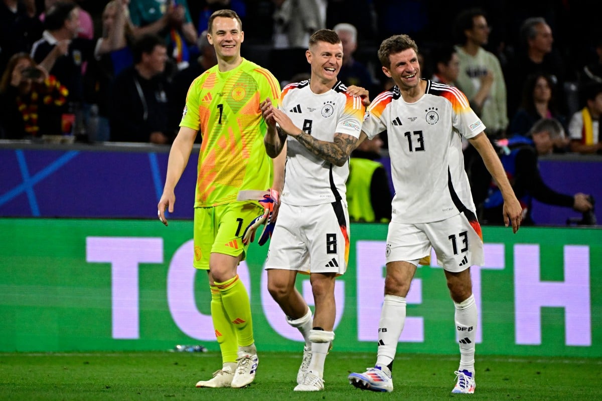 Germany's midfielder #08 Toni Kroos (C), Germany's forward #13 Thomas Mueller (R0 and Germany's goalkeeper #01 Manuel Neuer (L) celebrate on the pitch after the UEFA Euro 2024 Group A football match between Germany and Scotland.