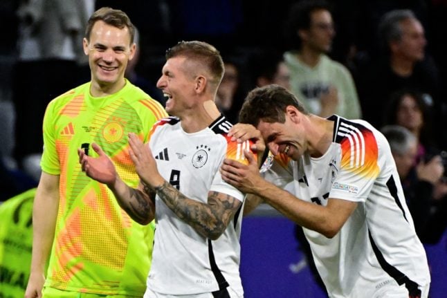 Germany's midfielder #08 Toni Kroos (C), Germany's forward #13 Thomas Mueller (R) and Germany's goalkeeper #01 Manuel Neuer (L) celebrate on the pitch after the UEFA Euro 2024 Group A football match between Germany and Scotland at the Munich Football Arena in Munich on June 14, 2024.