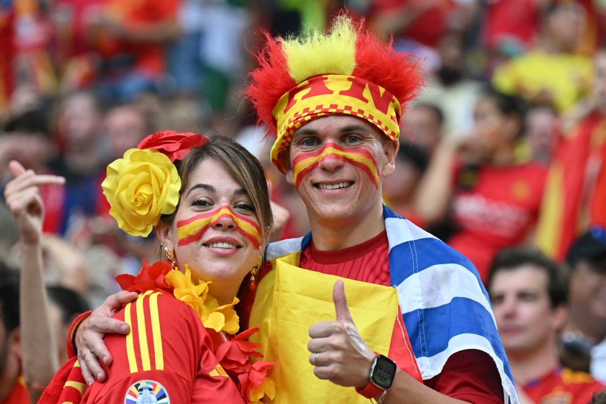 Spain fans pose for a picture ahead of the UEFA Euro 2024 semi-final football match between Spain and France at the Munich Football Arena in Munich on July 9, 2024.