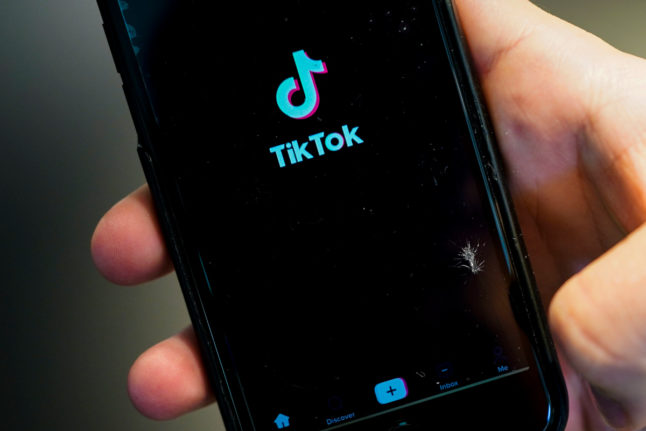 a person holding a phone with the start page of the tiktok app