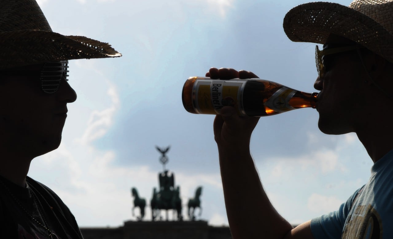 Men drink beer by Brandenburg Gate