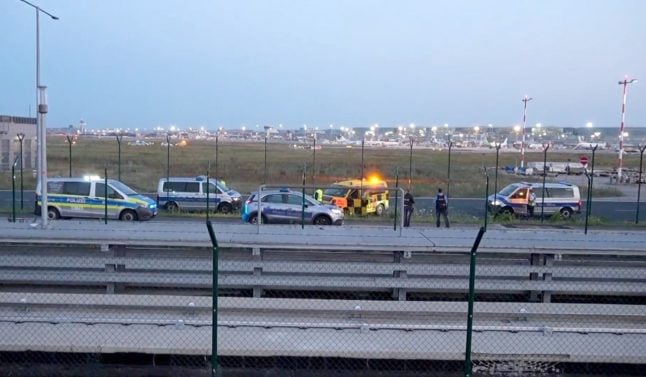 Police cars are seen on the runway of Frankfurt airport after climate activists breach the area.